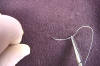 Suture needle is grasped with a needle holder